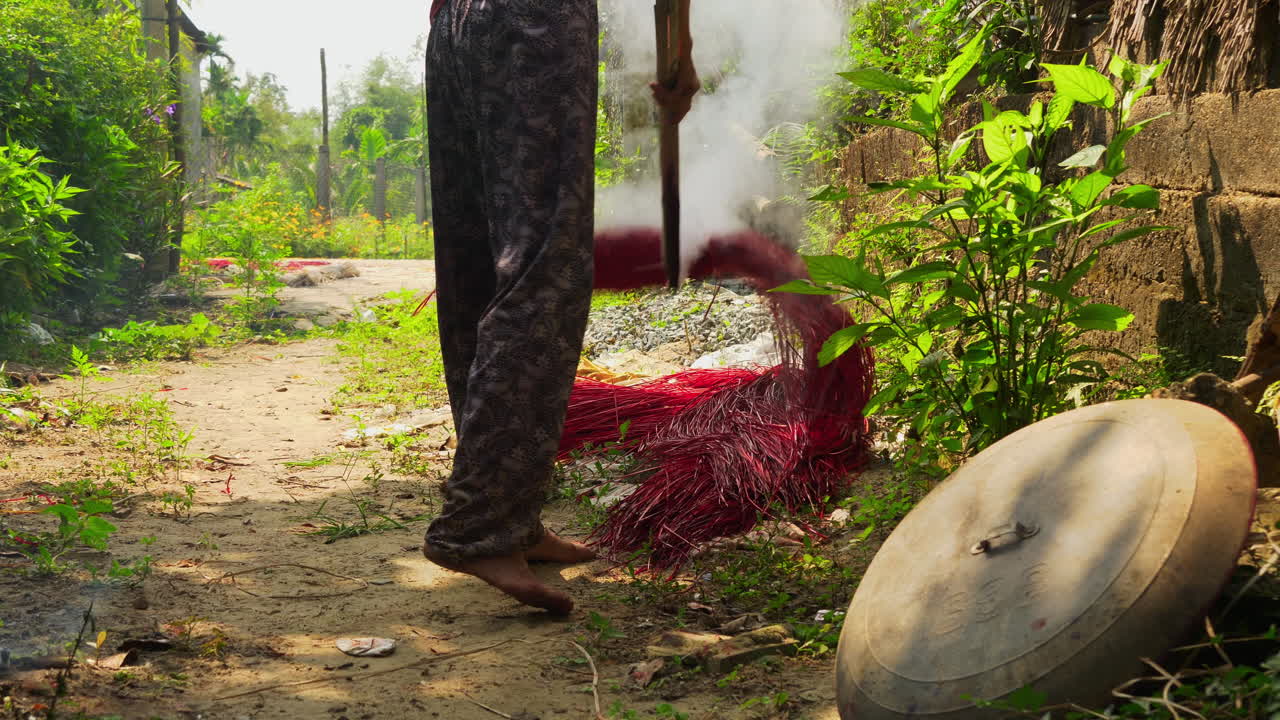 갓 염색한 붉은 빨대를 바닥에 널어 말리는 사람