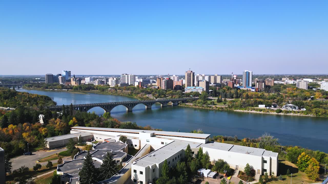 Vista aérea ampla do centro de Saskatoon no outono, entrada da ponte, céu azul, beira do rio