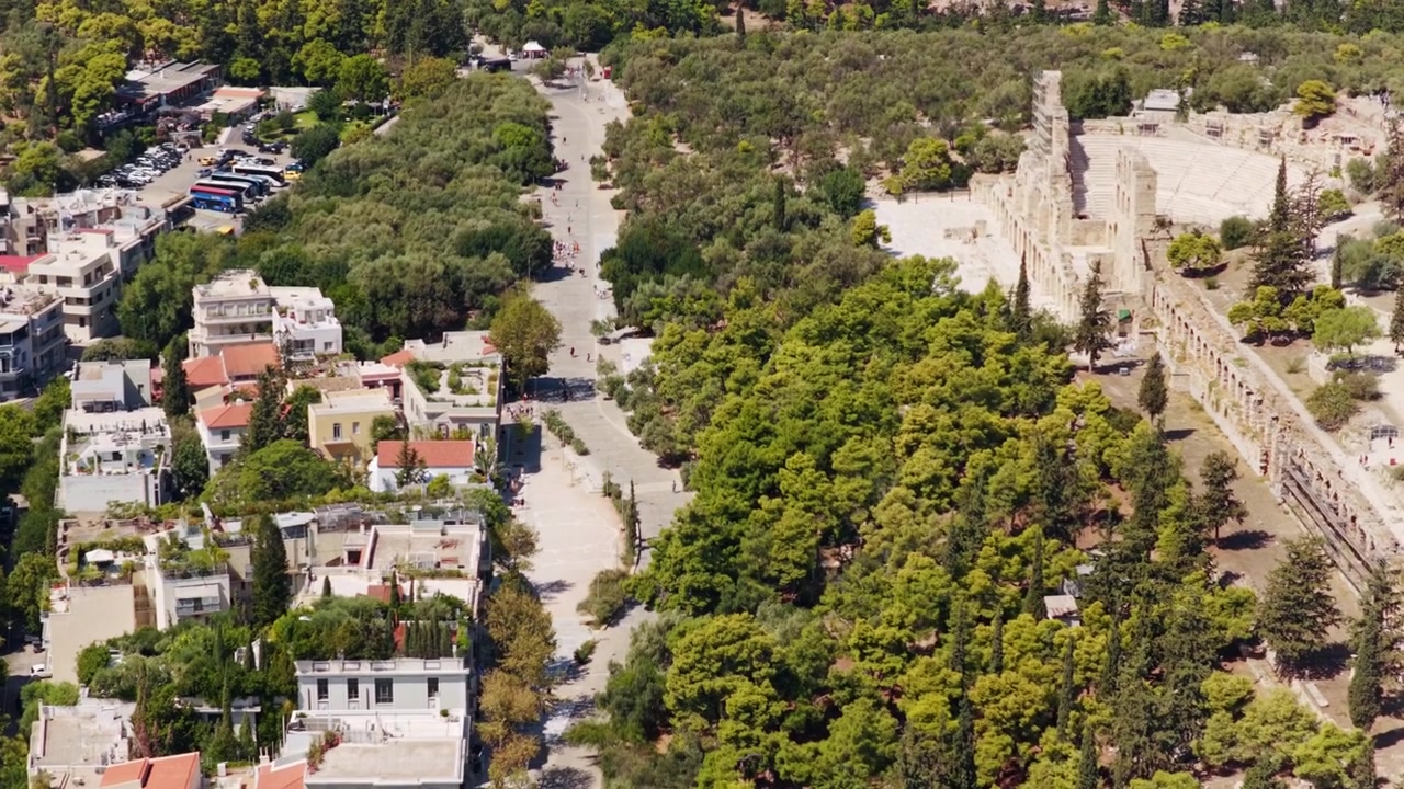 Splendide riprese aeree che mostrano l'antico Odeon di Erode Attico e la via Dionysiou Areopagitou, rivelando il paesaggio urbano storico e la vegetazione rigogliosa di Atene, in Grecia