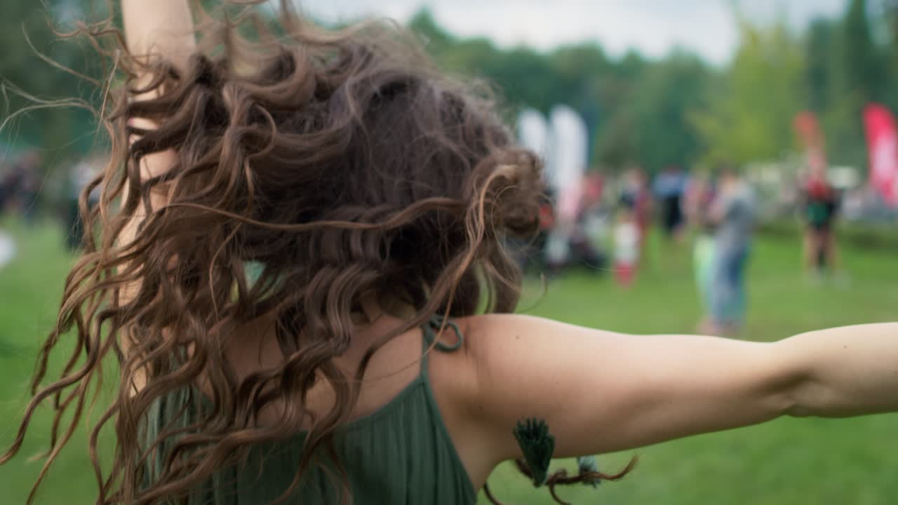 음악 페스티벌에서 카메라 쪽으로 돌아다니는 백인 여성의 클로즈업. 8k의 레드 헬 카메라로 촬영.