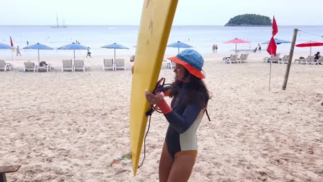 mujer con una tabla de surf en la playa