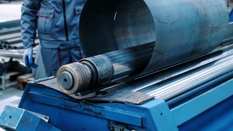 engineers serve metal rolling machine in industrial workshop. craftsmen working