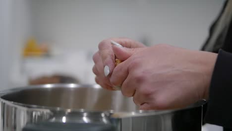 Closeup-of-woman's-hands-while-cutting-trahana-pieces-into-a-large-pot