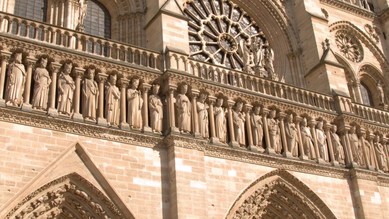 La telecamera si inclina verso l'alto sulla facciata gotica ornata della Cattedrale di Notre Dame a Parigi, Francia
