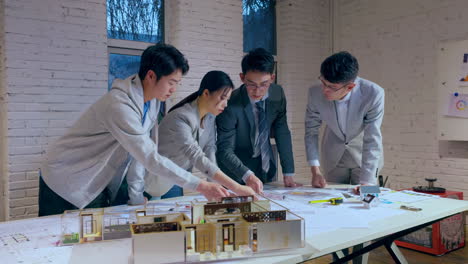 discussion with real estate investment, construction business, architecture and building concept - group of architects with laptop computer discussing blueprint at office