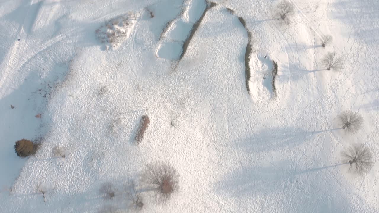 Il drone si allontana e inquadra verso il basso per mostrare il country club innevato, le aree di partenza e altre caratteristiche del campo da golf dopo la bufera