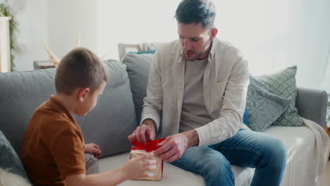 little boy helps his dad prepare christmas presents