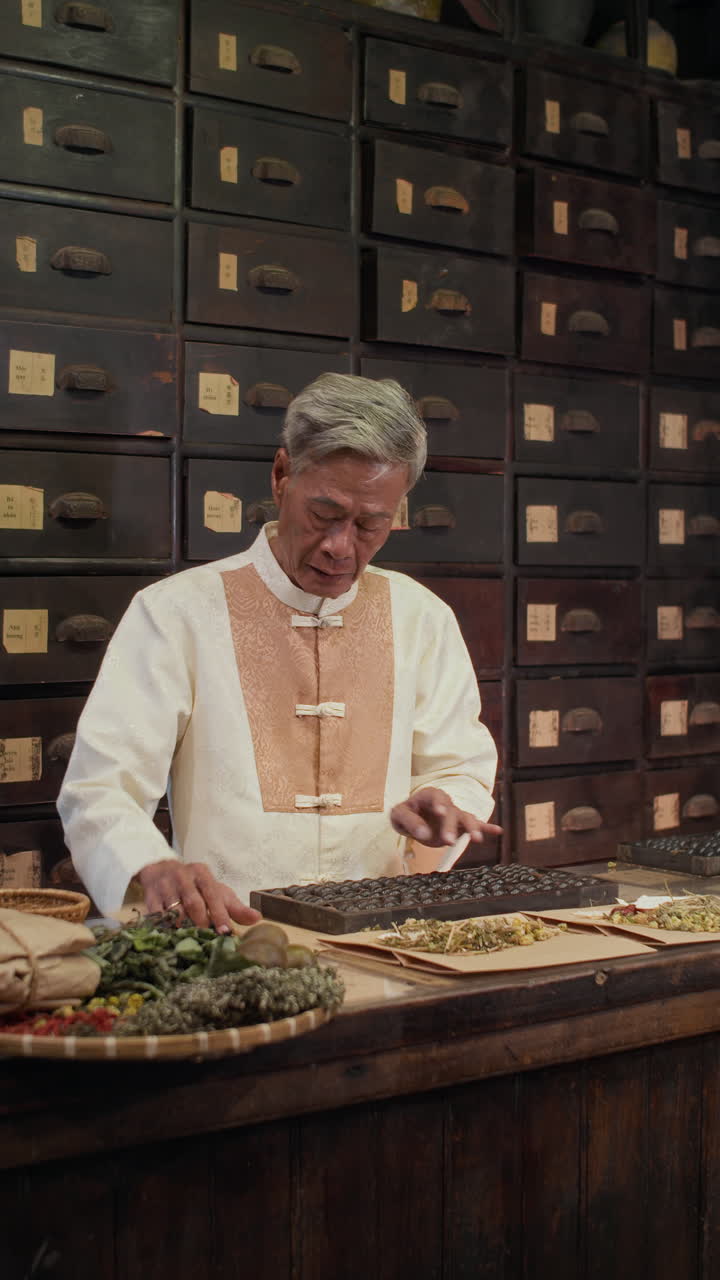 Aged Apothecary Calculating on Abacus when Working with Herbs