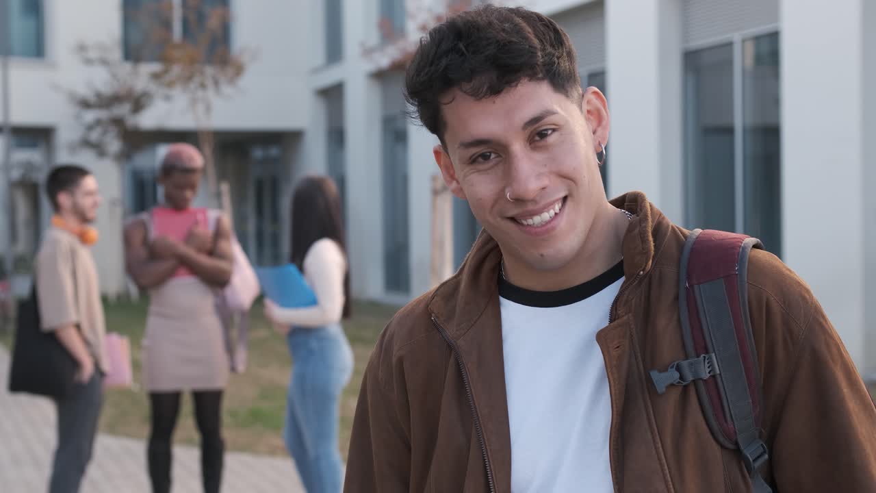Smiling latin young man looking at the camera outside the university