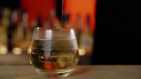 pouring a whiskey cocktail