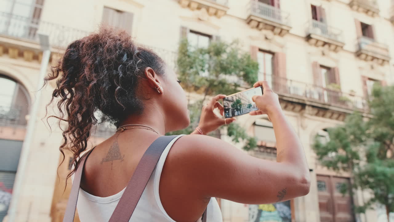 Donna che scatta foto in una via della città