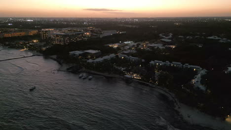 Drone-Sobre-Resort-Por-La-Noche-En-Playa-Del-Carmen,-México-Tiro-De-Paralaje