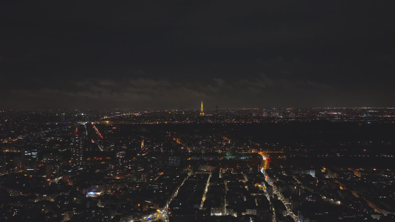 сверху танцуют городские огни, а эйфелева башня светит над городом.