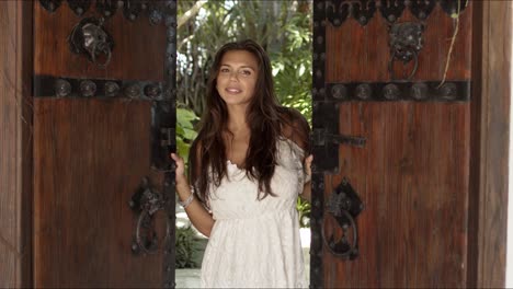 cheerful woman opening old wooden doors