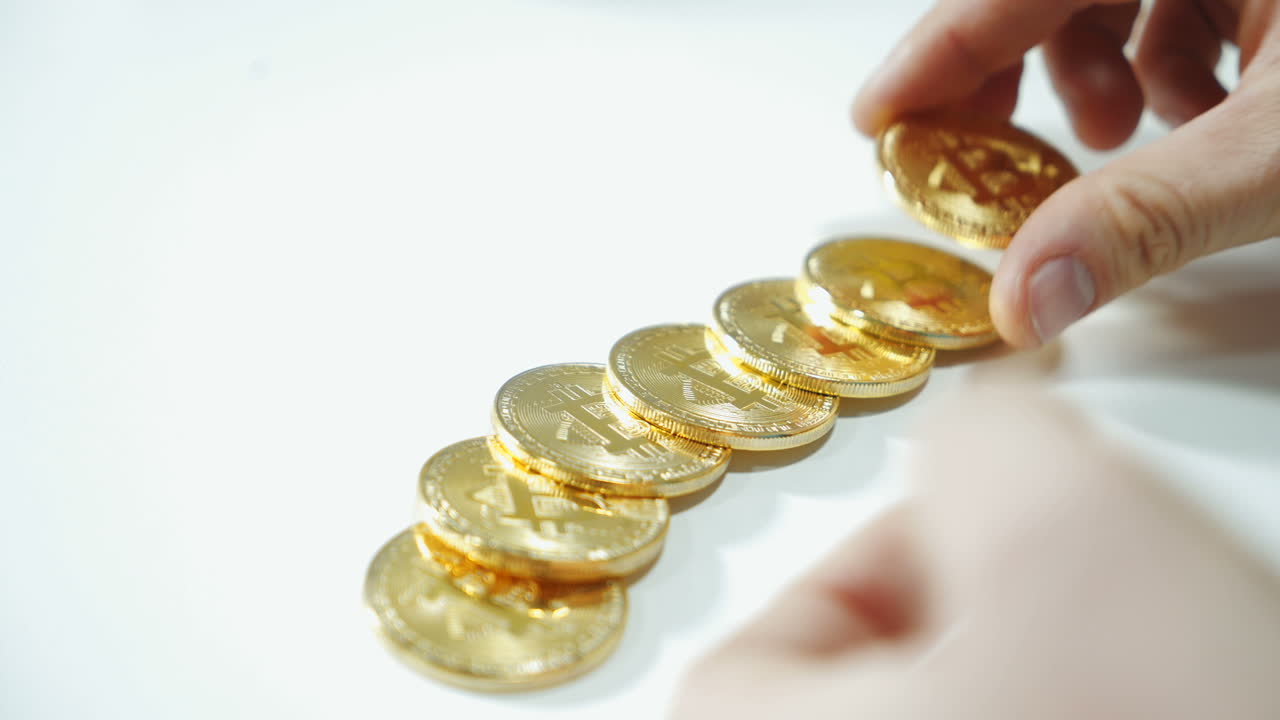 Man considers coins bitcoin. Cryptocurrency concept. Gold bitcoin in the hand of man. Digital symbol of the new virtual currency.