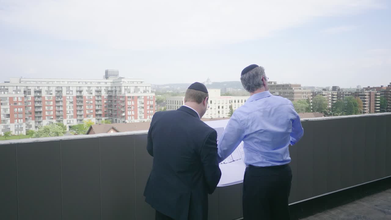 dos hombres de negocios judíos inspeccionan un sitio de construcción de varios niveles