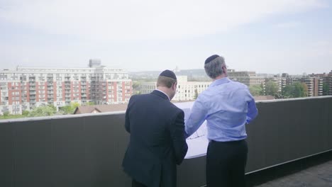 dos hombres de negocios judíos inspeccionan un sitio de construcción de varios niveles