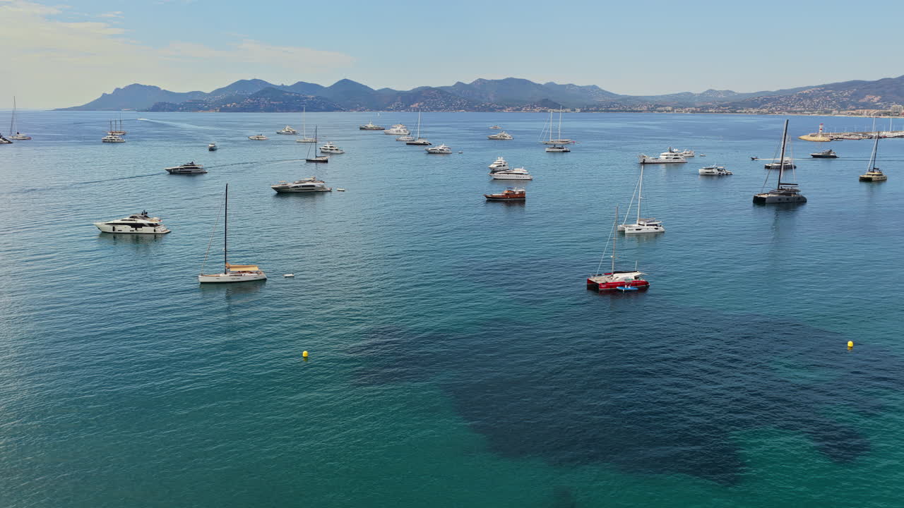 Vista aerea da drone di decine di yacht e barche a vela ancorate nelle calme acque turchesi al largo di Cannes