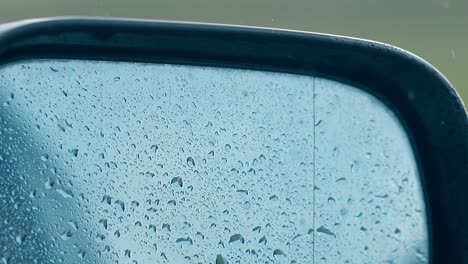 close view car side mirror with water drops under light rain