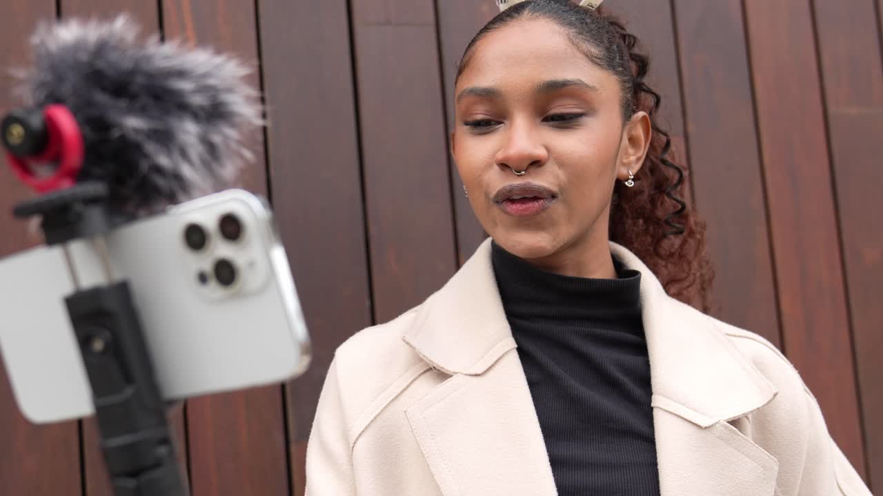 Donna che fa un vlog con un telefono cellulare e un microfono
