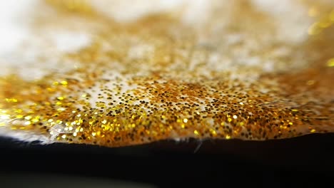 golden wet glitter on a uneven edge of paper