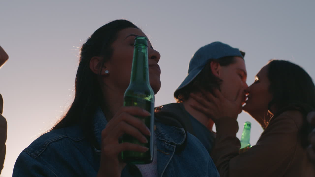 mixed race woman dancing group of diverse friends hanging out enjoying rooftop party dance music at sunset drinking having fun on weekend gathering