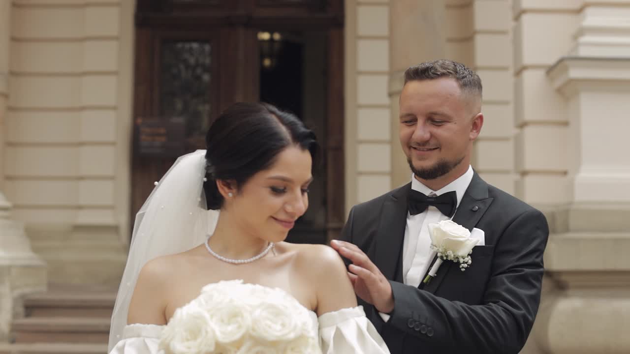 retrato de recién casados, novio y novia caucásicos caminando, abrazándose, abrazándose cerca del viejo castillo, pareja de bodas