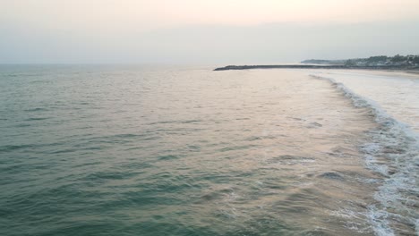enchanting aerial drone shot of kanyakumari, blending the urban landscape and ocean under a fiery sunset.