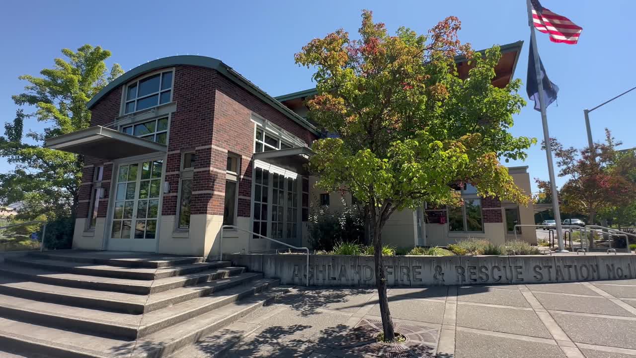 Waving Flag At Ashland Fire And Rescue Station No. 1 During Sunny Day In Ashland, Oregon, United States. Static Shot