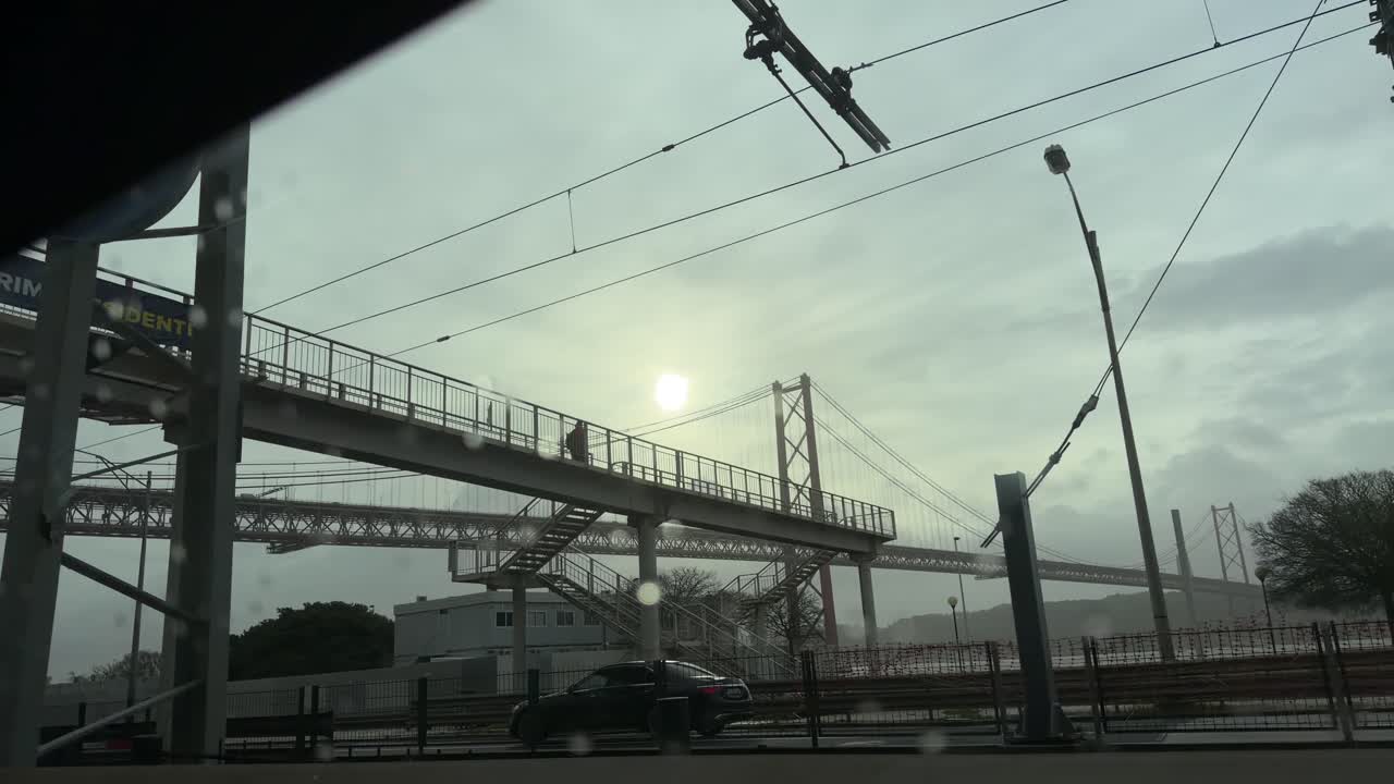 Vista da Ponte 25 de Abril em Lisboa com o sol a romper as nuvens