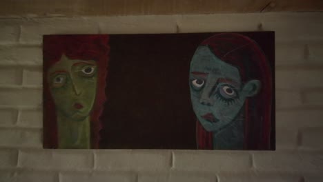 dolly-in close-up view of surreal painting on wall inside superadobe house. sad man and woman