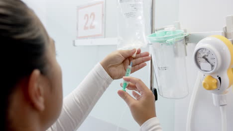 doctora biracial preparando un goteo en la habitación del hospital, en cámara lenta