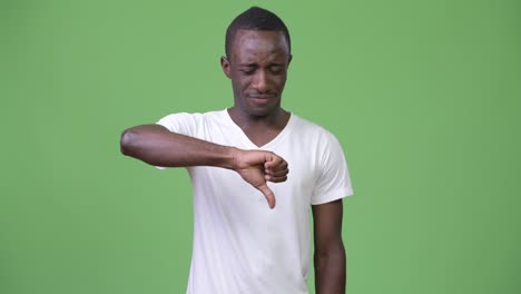 joven africano triste dando pulgares hacia abajo