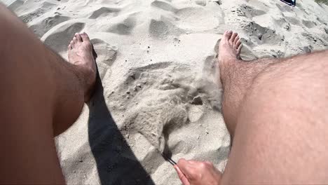 jugando con un palo en la arena cámara lenta en primera persona
