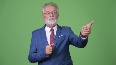 hombre de negocios barbudo y guapo contra un fondo verde.