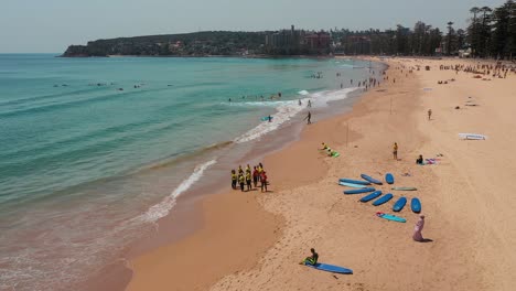 beginner surfers during surf school class standing ocean side on beautiful beach in sydney during vacation, water sports aerial shot