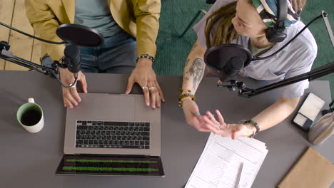 top view of man hands and woman hands gesticulating on the table while they recording a podcast