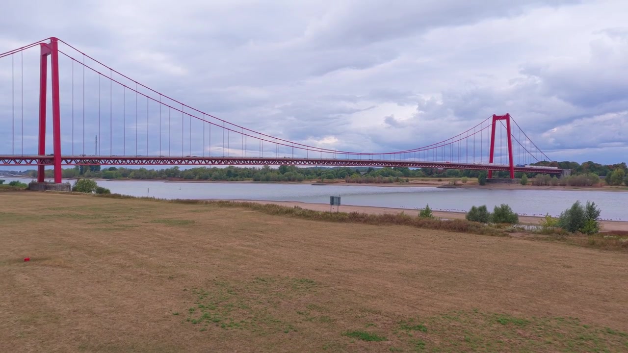 Vista aérea de uma grande ponte pênsil vermelha sobre um rio