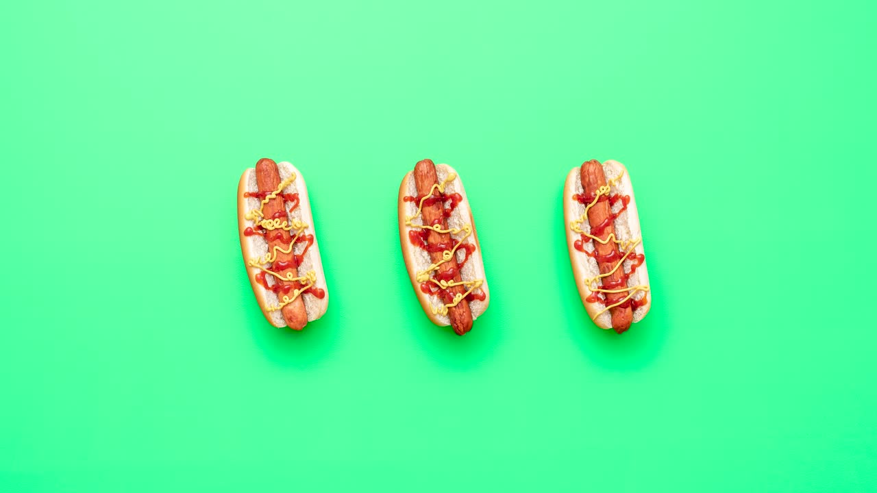 녹색 테이블 위에서 핫도그를 만들고 먹는 핫 도그.