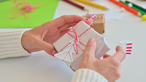 female hands decorate an original wrapped gift