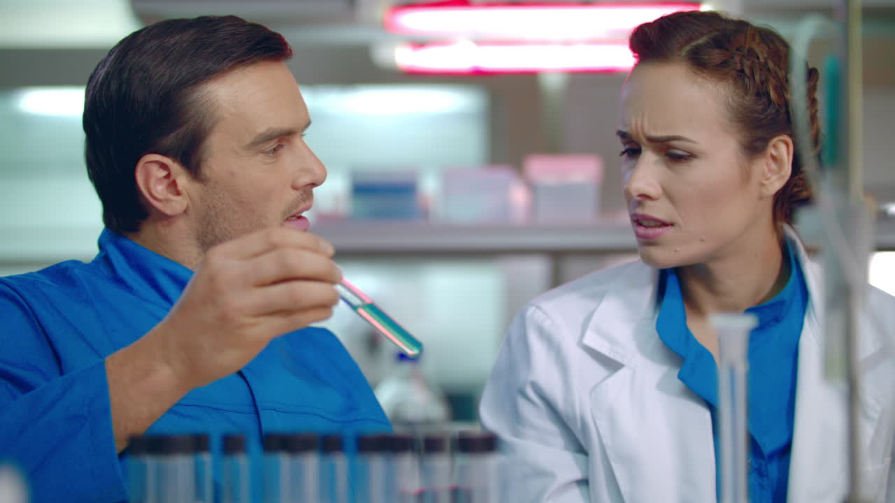 Scientist team working in lab. Scientist discussing liquid sample in test tube