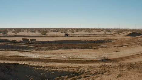 vista aérea en cámara lenta de carreras de motocross en pista de tierra en el desierto de mojave