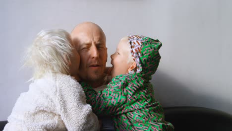 niños besando a su padre en la sala de estar 4k