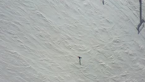 la gente disfruta del invierno mientras esquía por laderas nevadas, vista aérea de arriba hacia abajo