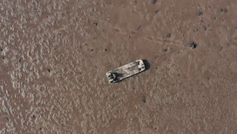 barge for shellfish farming tide out moored in mud from above