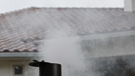 smoke coming out of bbq pit chimney in backyard