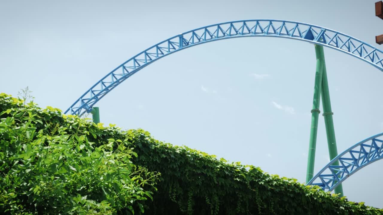 놀이 테마 파크. 롤러코스터 타기. 은 여름날에 롤러 코스터를 타는 사람들. 행복한 활발한 가족 휴가