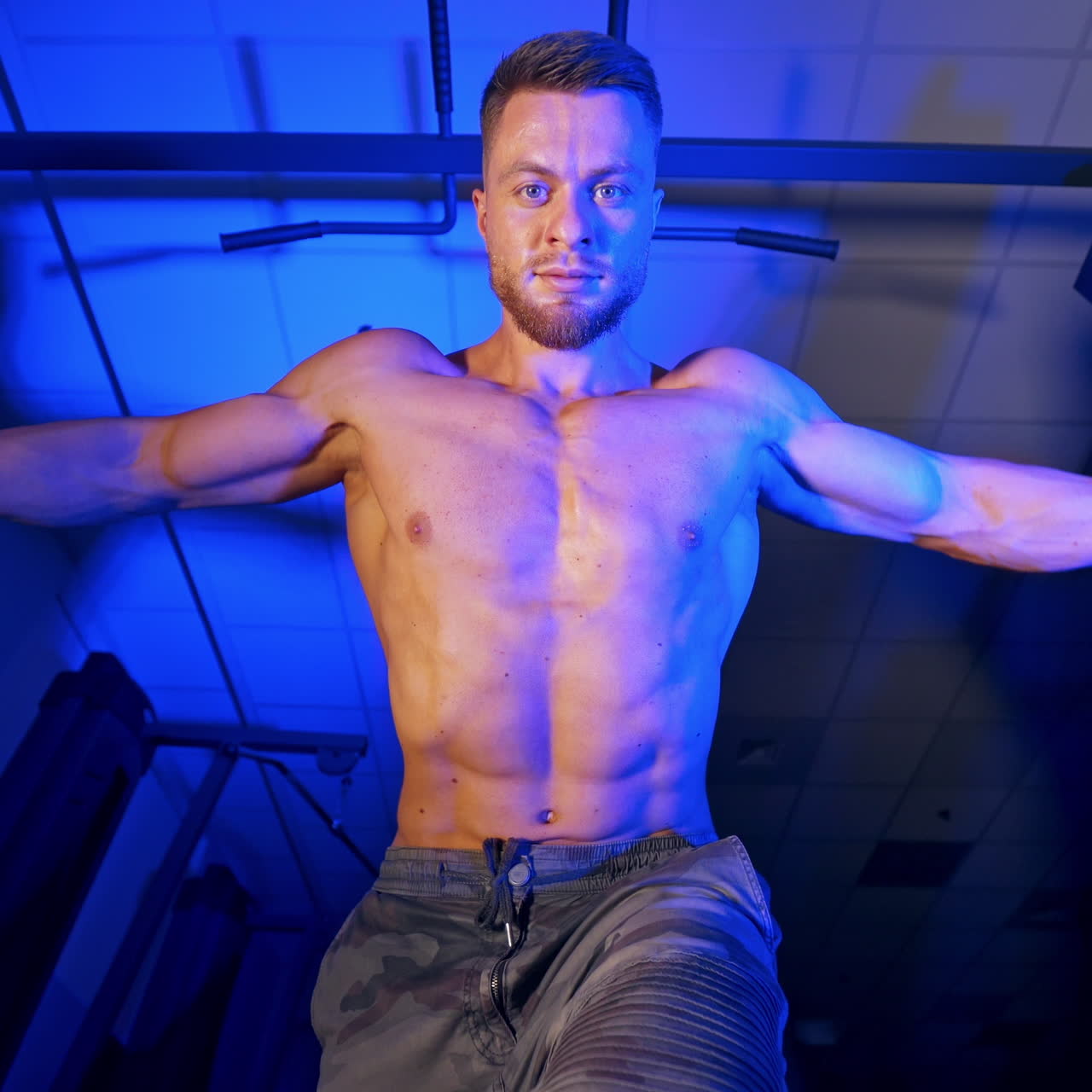 Athlete with strong body doing work out pushing up excercise in gym. View from the bottom.