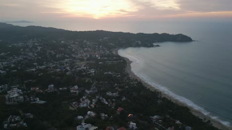 Las-Olas-Del-Océano-Rompen-En-Un-Largo-Tramo-De-Arena-Con-Casas-Con-Vistas-A-La-Costa-En-Sayulita,-México.