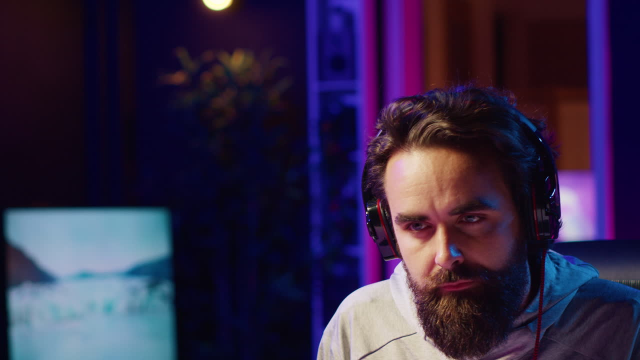 fotografía de cerca de un hombre que se pone auriculares mientras juega videojuegos en casa